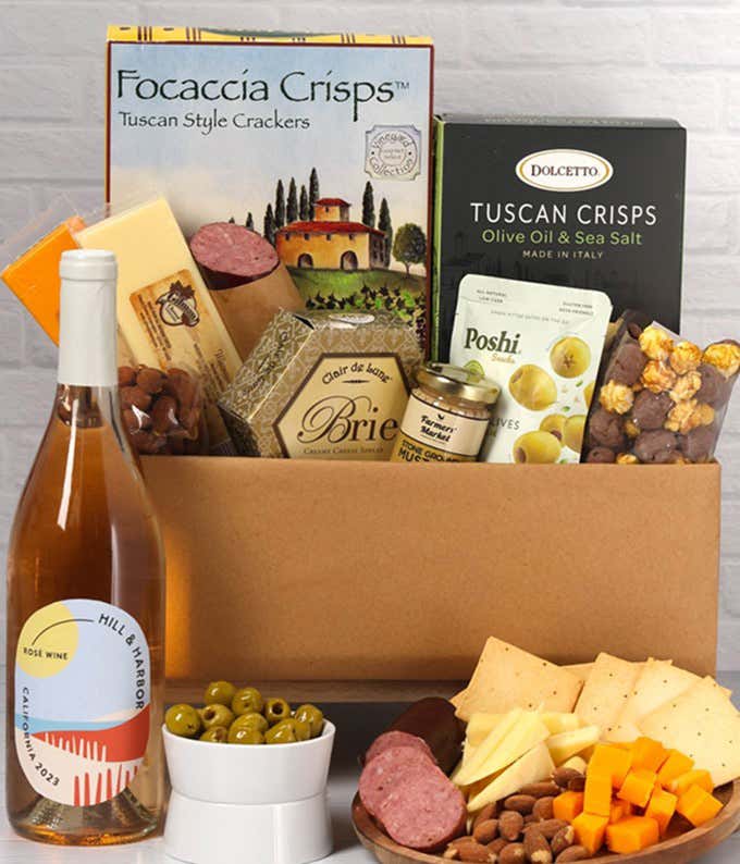 An abundent gift box filled with California Rosé Wine, assorted crackers, two cheeses, summer sausage, and snacks to make an amazing charcuterie spread. 