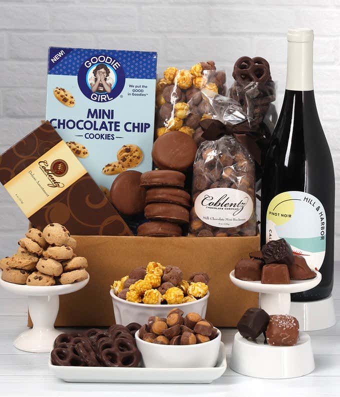 A gift set featuring a bottle of California Pinot Noir with chocolate pretzels, caramel popcorn, mini cookies, chocolate peanut butter buckeyes, 6 chocolate-covered Oreos and a box of assorted chocolates for a luxurious touch.