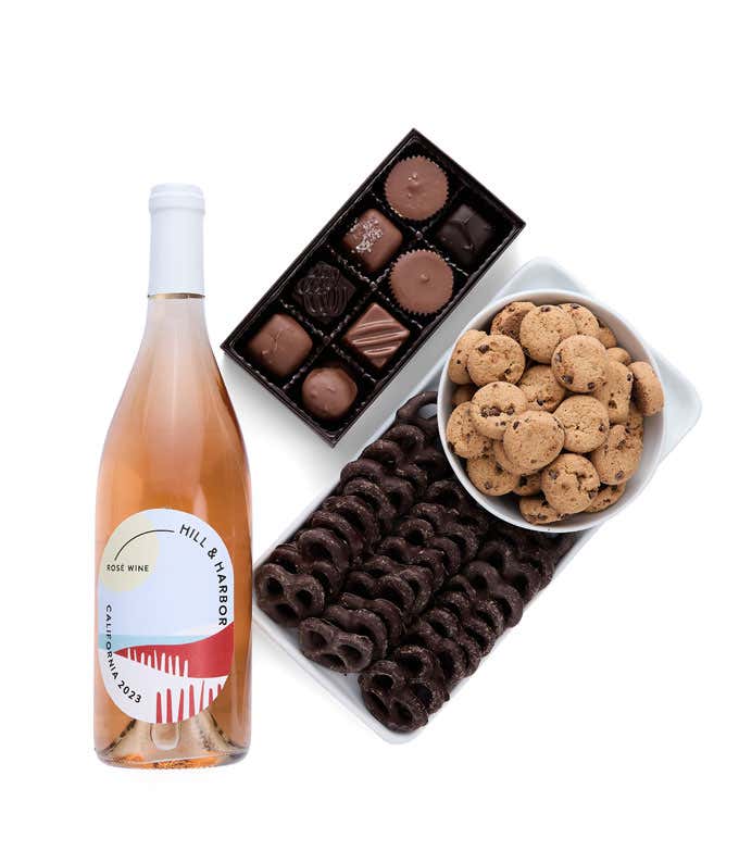 a gift box full of decadent treats.  Contents include: a bottle of California Rosé wine, a bag of milk chocolate pretzel, a box of mini chocolate chip cookies, and a 4-ounce box of assorted chocolates.